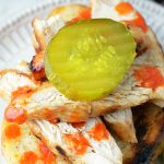 nashville hot grilled chicken on garlic bread topped with a dill pickle slice