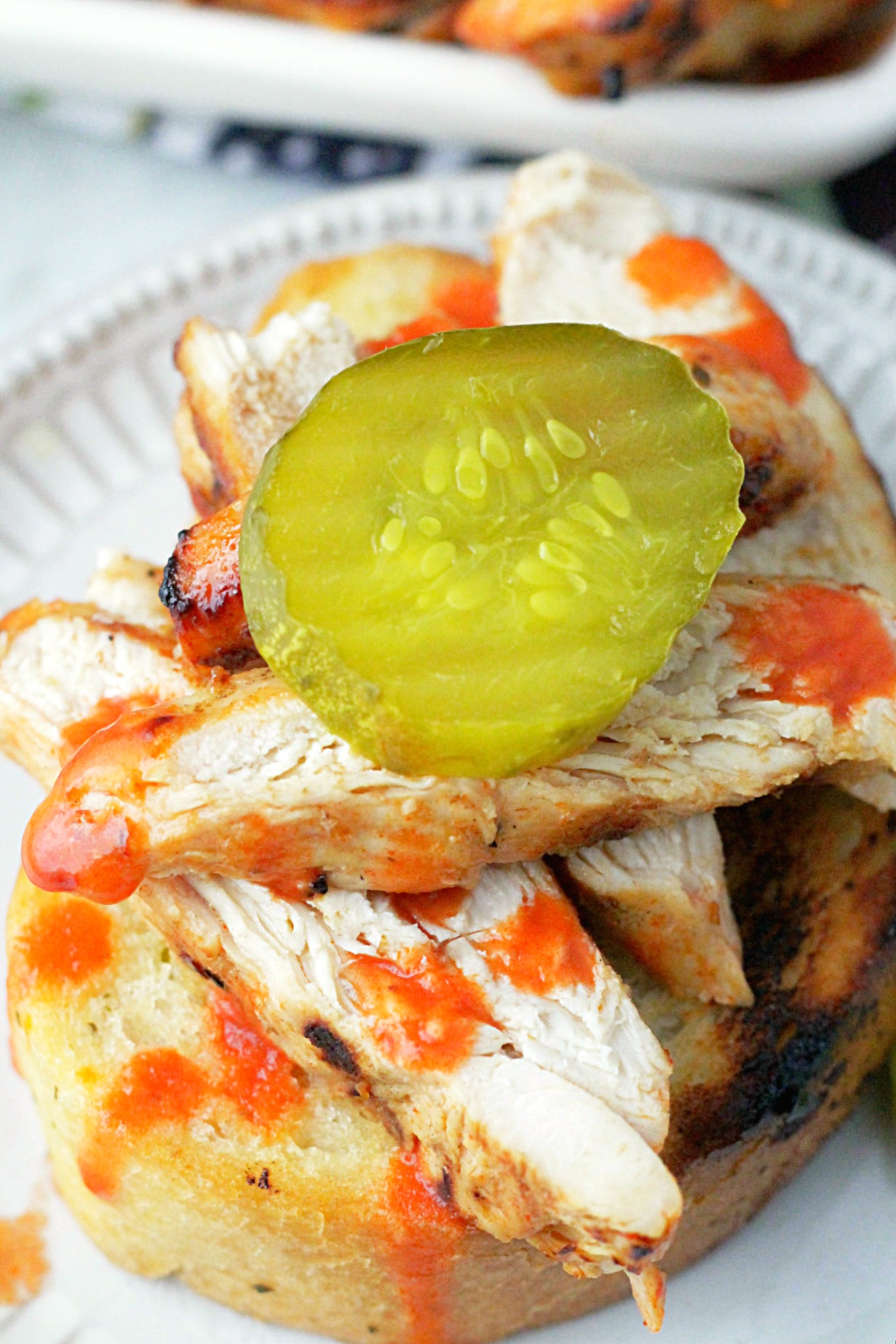 nashville hot grilled chicken on garlic bread topped with a dill pickle slice