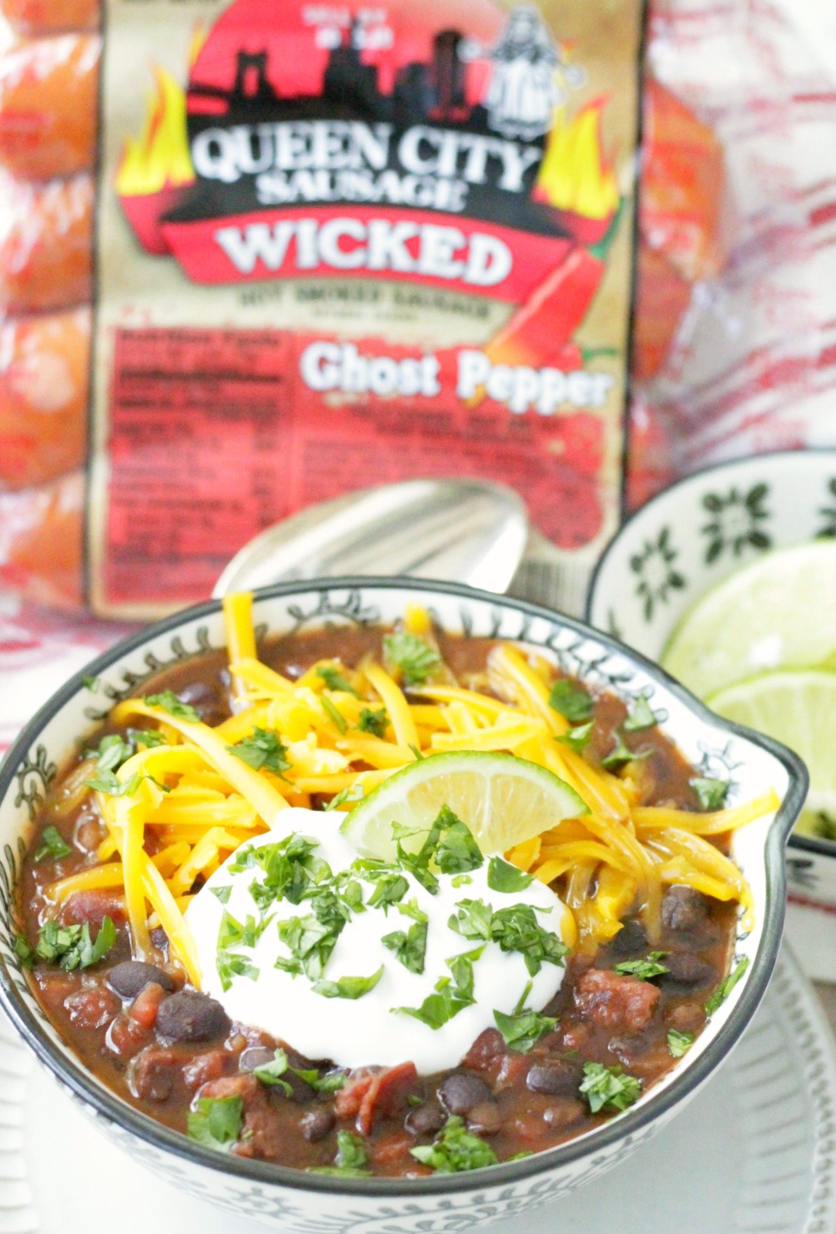 bowl of wicked black bean and ghost pepper sausage soup with package of queen city sausage