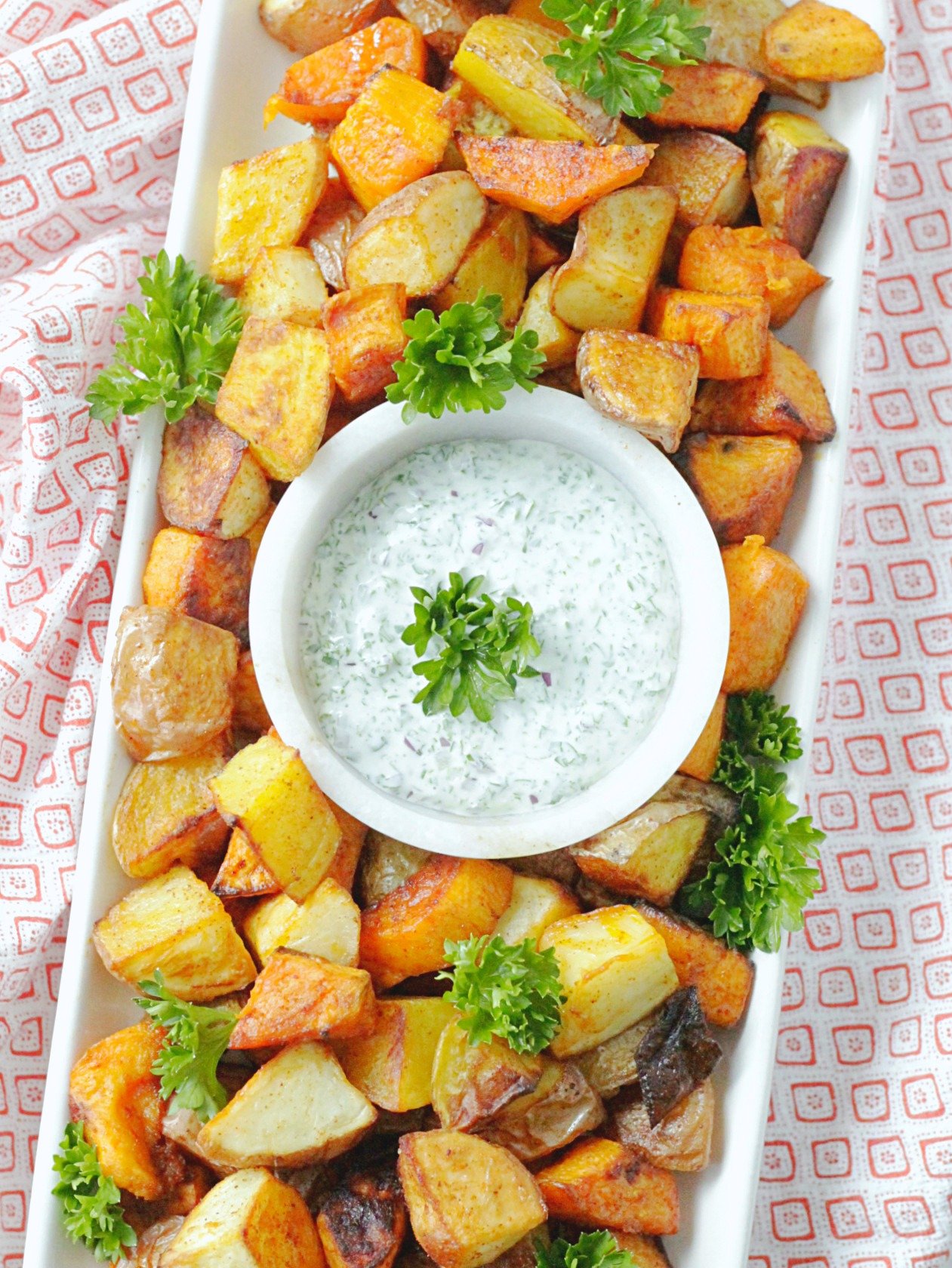 overhead view of perfect oven roasted potatoes on platter with dipping sauce