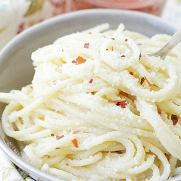 easy and perfect buttered spaghetti in bowl with glass of rosé wine