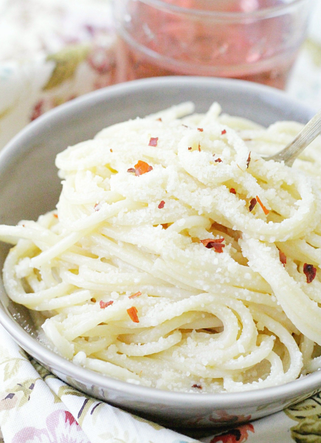 easy and perfect buttered spaghetti in bowl with glass of rosé wine