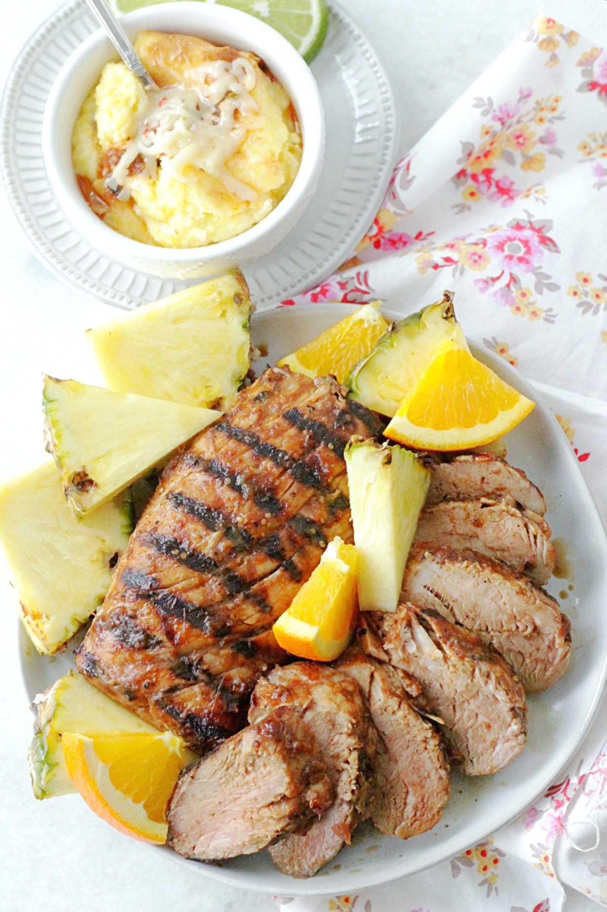 overhead view of al pastor grilled pork tenderloin on plate with pepper jack cheesy grits