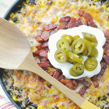 one skillet cowboy rice topped with bacon, sour cream and pickled jalapeños