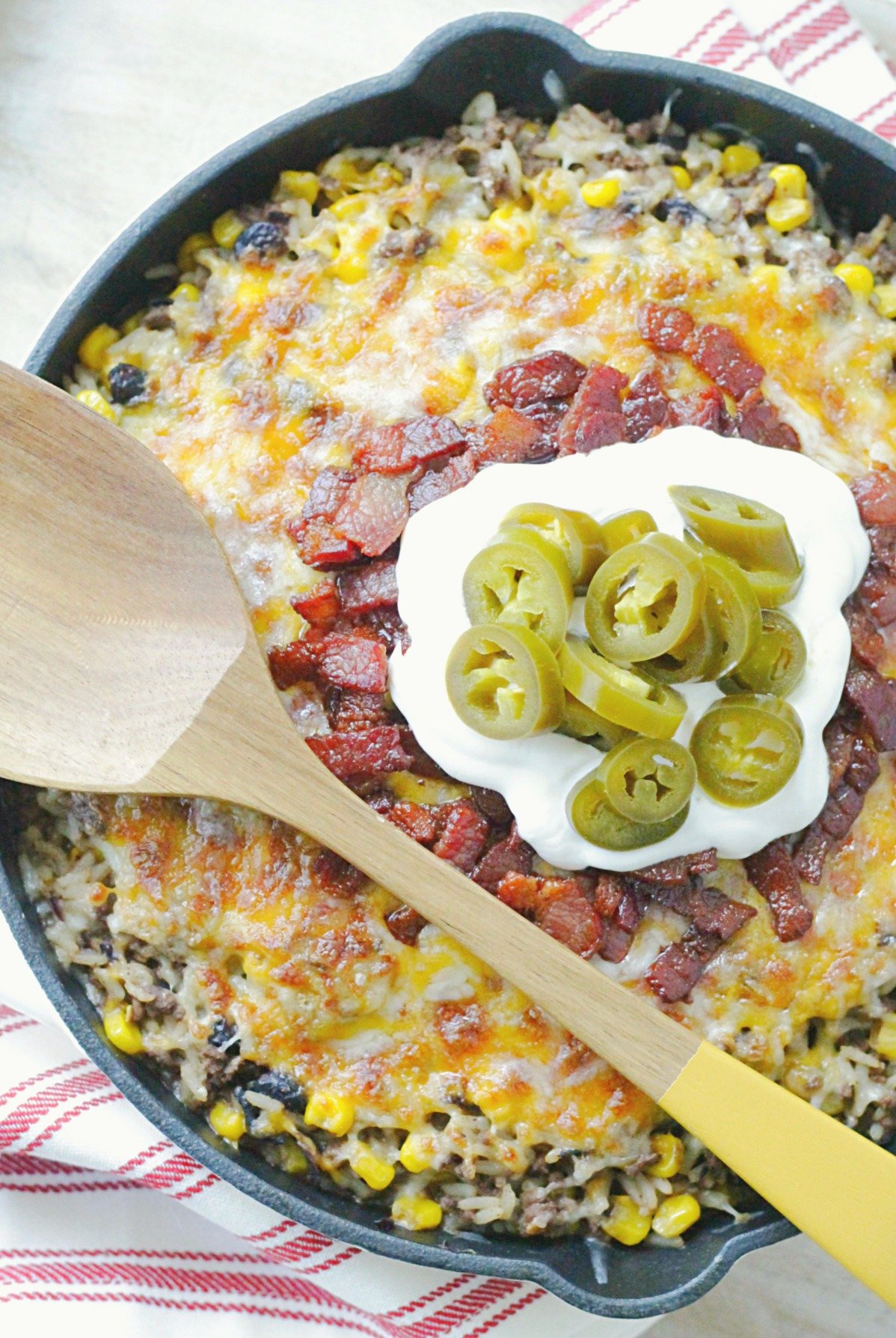 one skillet cowboy rice topped with bacon, sour cream and pickled jalapeños