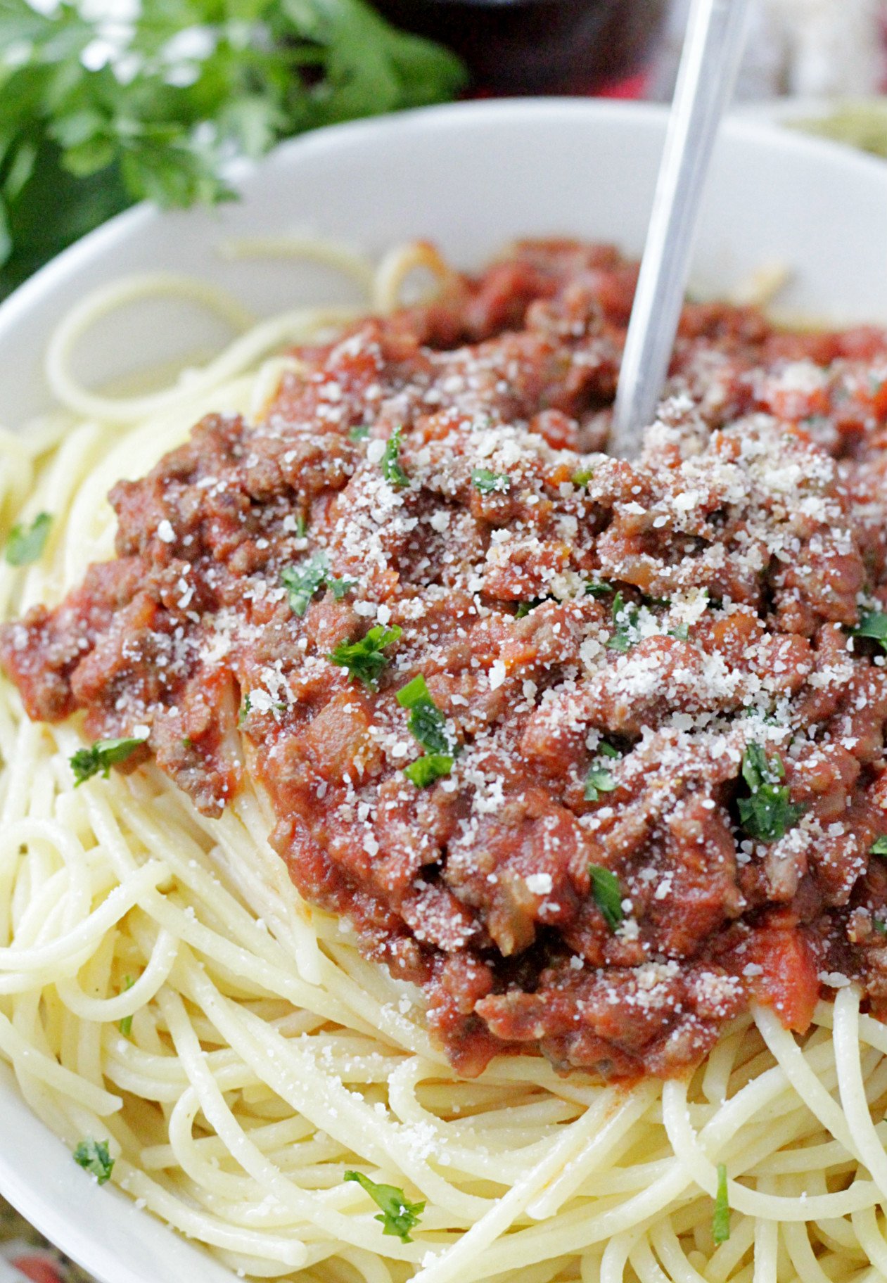 instant pot beef bolognese pasta sauce on spaghetti and topped with parmesan cheese