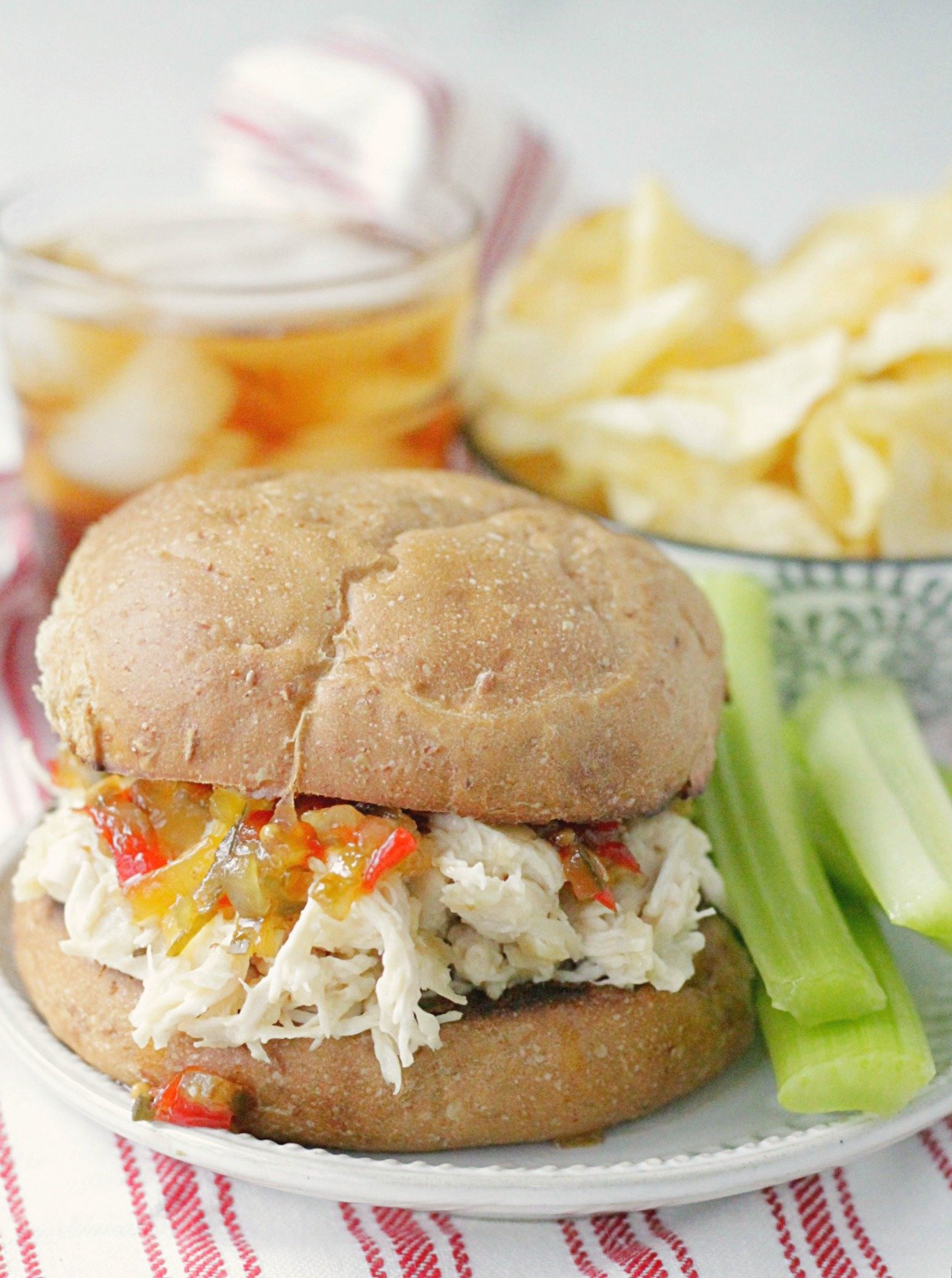 shredded chicken sandwich on plate with celery