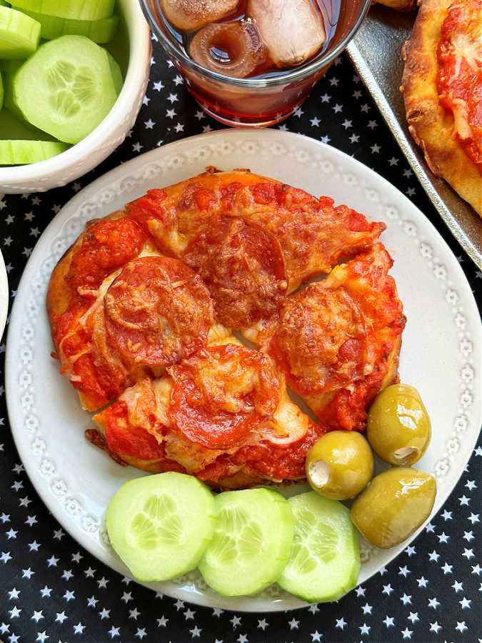 air fryer pizza plated with cucumber and olives