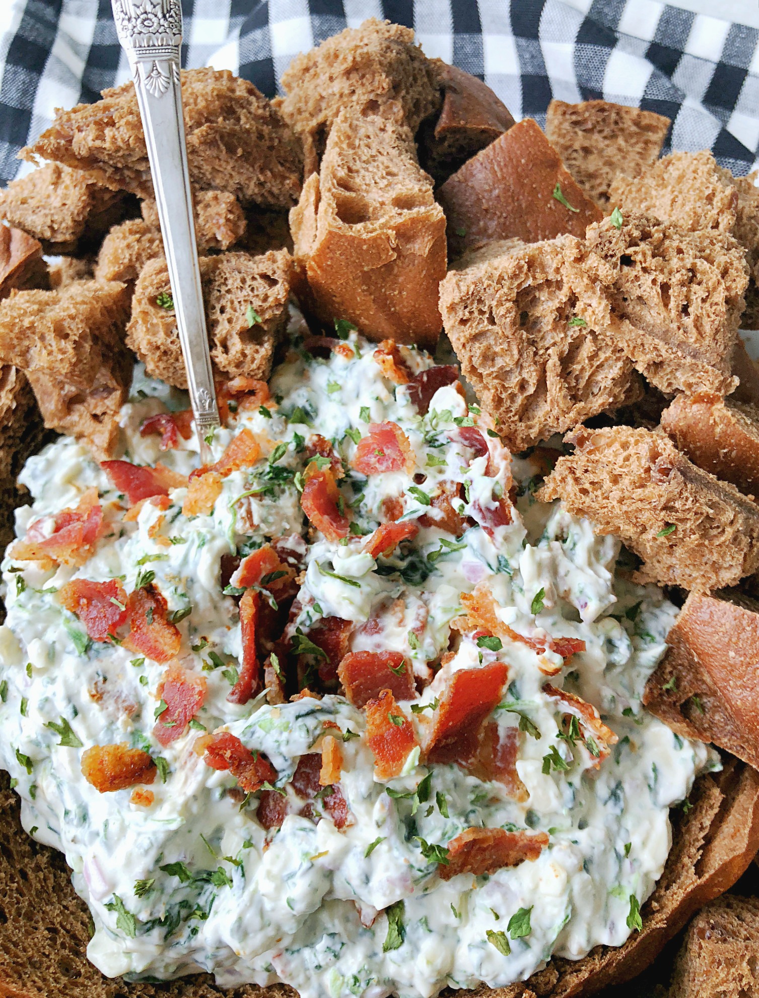 bacon party dip in a bread bowl with spoon