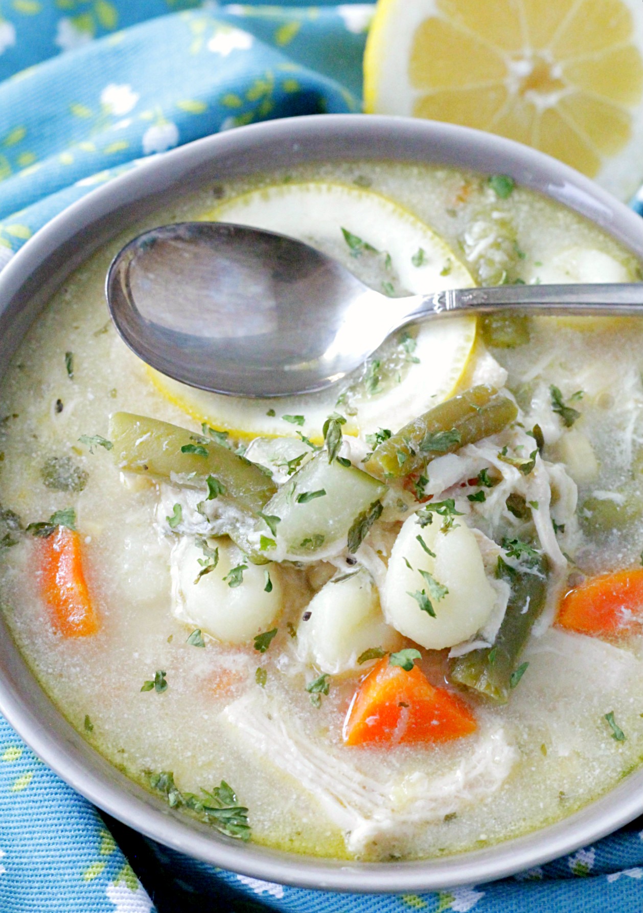 creamy lemon chicken gnocchi soup with spoon in bowl