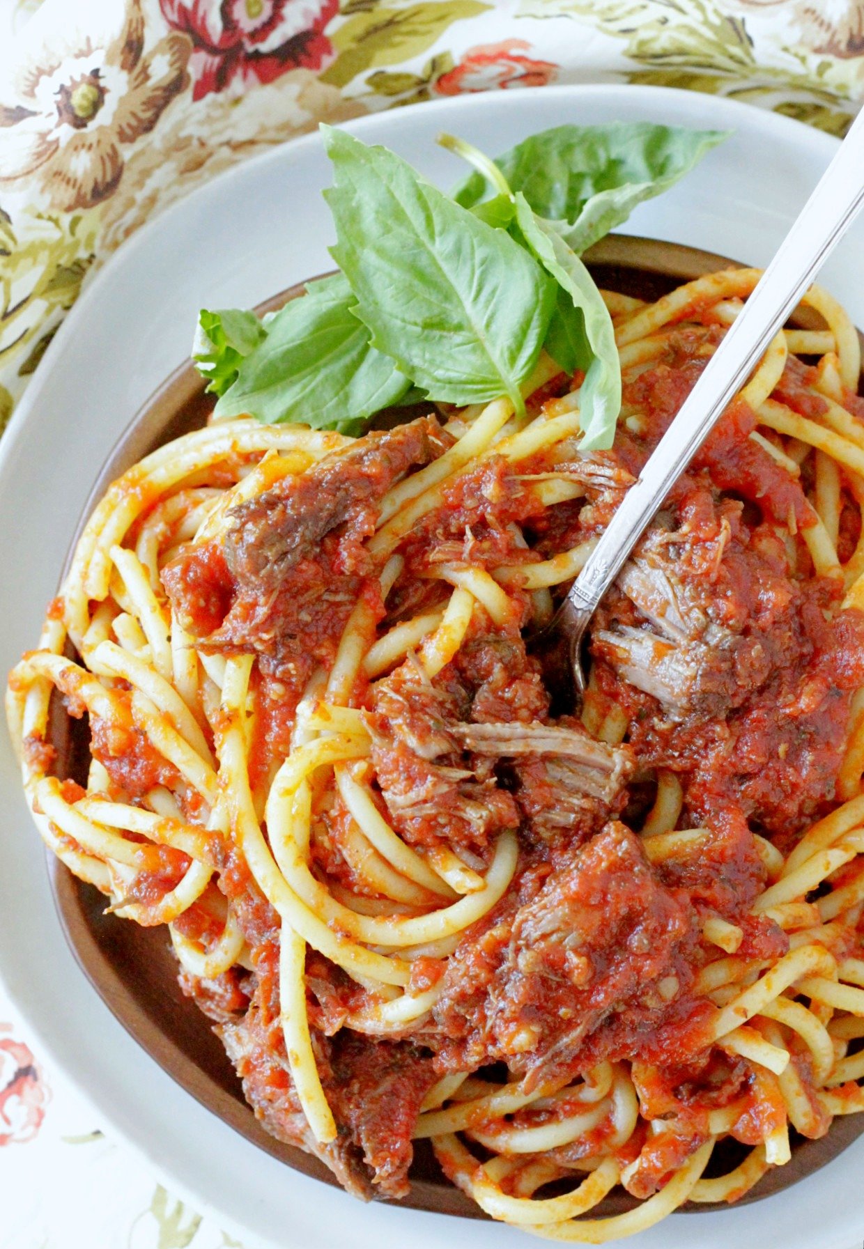 slow cooker sunday gravy on plate with pasta