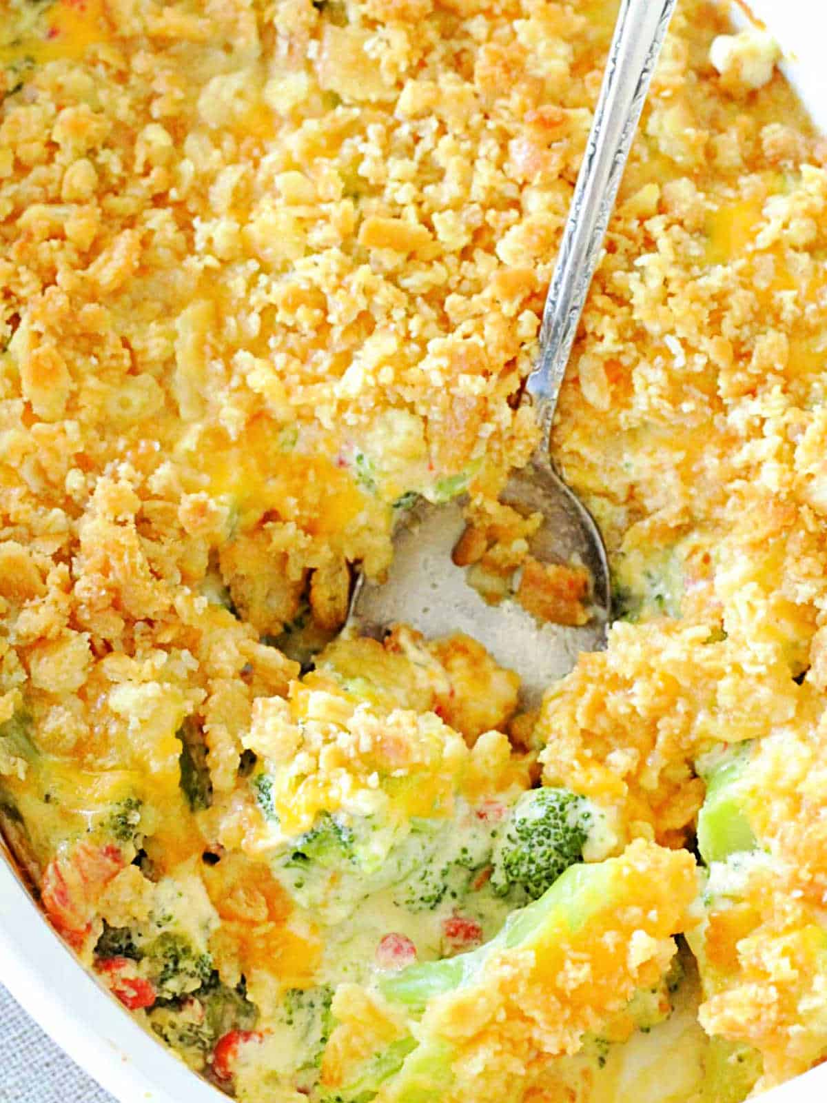 serving a spoonful of broccoli casserole from the baking dish