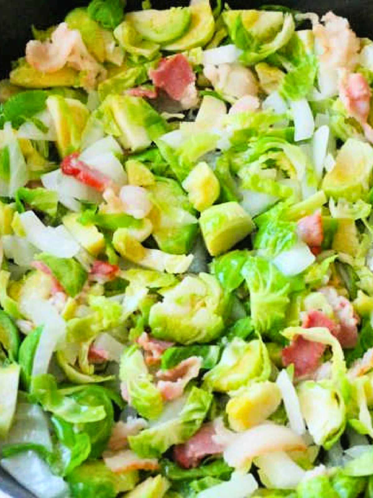 showing the bacon, brussels sprouts and onion cooking in the skillet