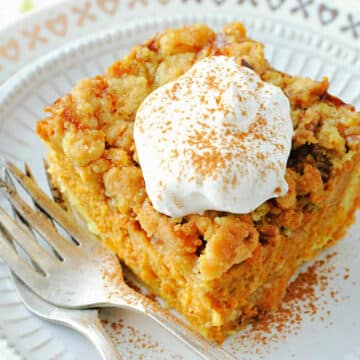 plated slice of pumpkin pie dump cake topped with a dollop of whipped cream