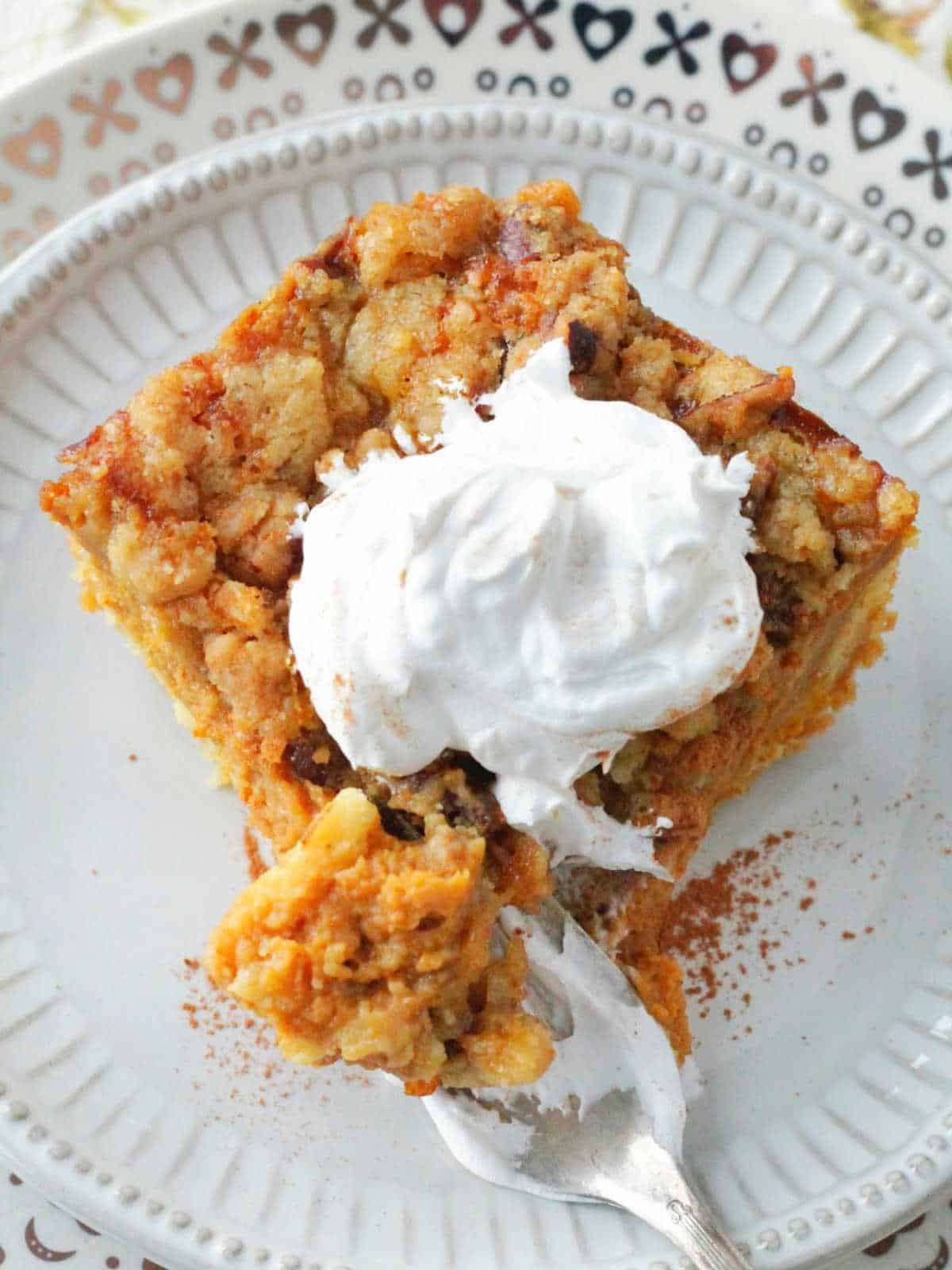a slice of pumpkin dump cake with a bite taken