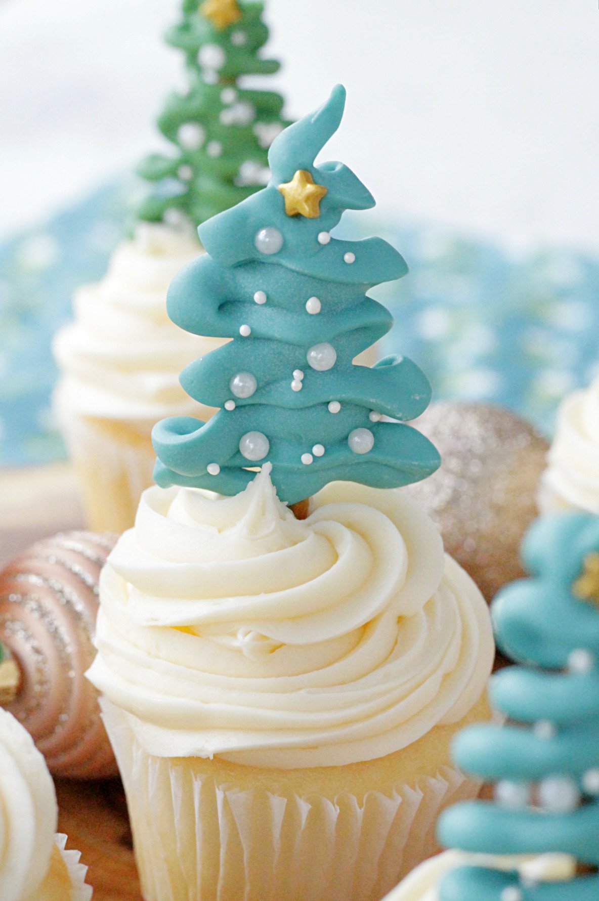 single christmas tree cupcake topper on top of cupcake on wooden platter