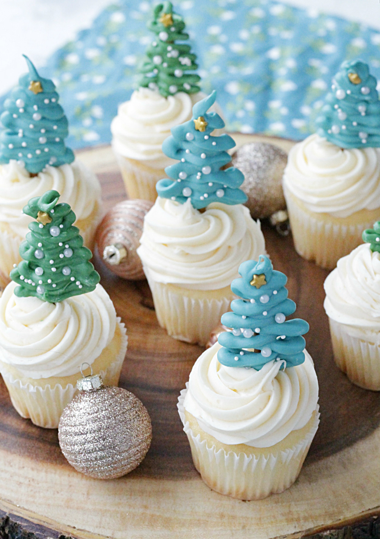 wooden platter of cupcakes topped with christmas tree cupcake toppers