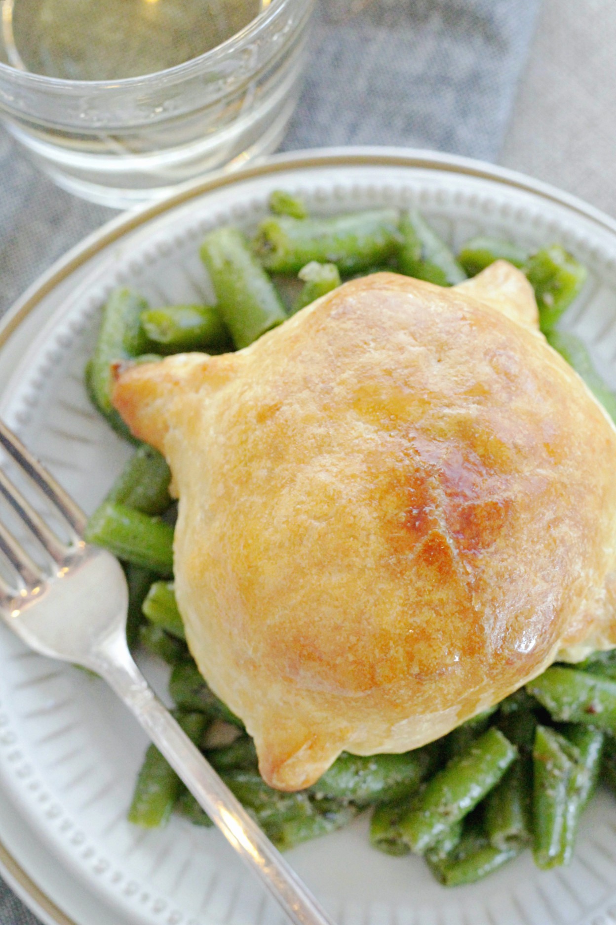 individual pork wellingtons recipe on plate with green beans