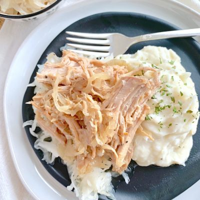 slow cooker pork and sauerkraut on plate with mashed potatoes