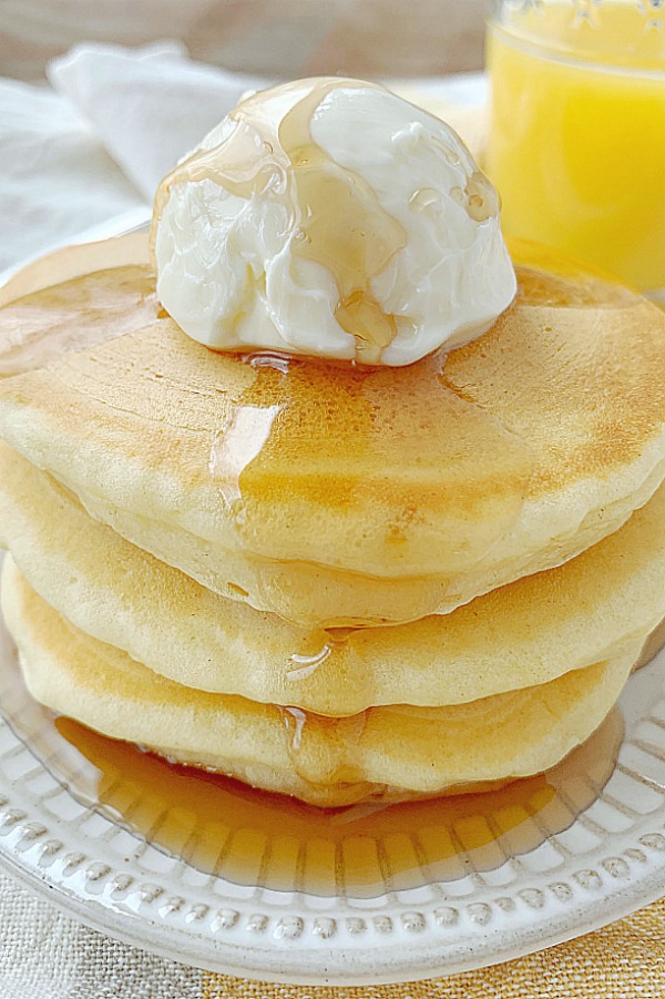 stack of buttermilk pancakes topped with butter and syrup