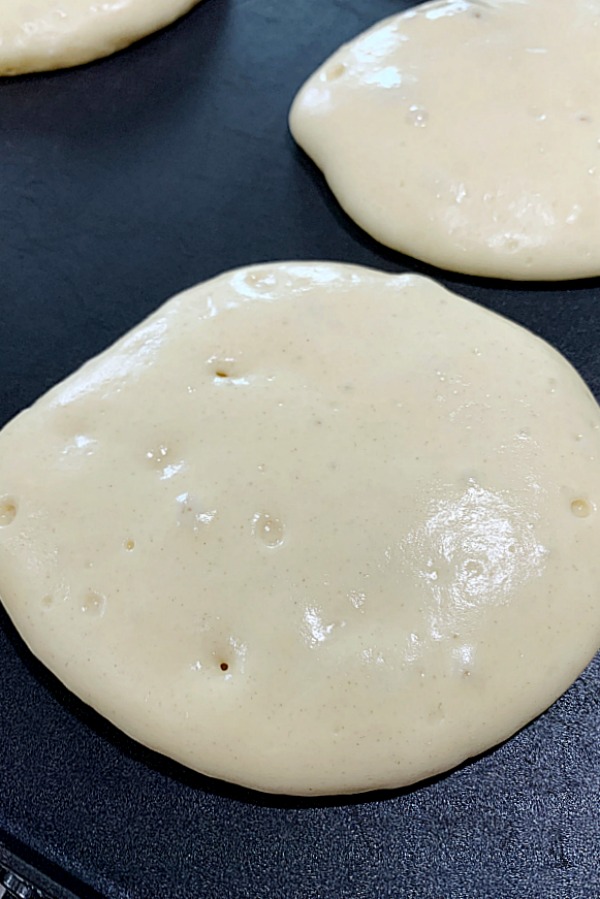 pancakes on griddle before being flipped