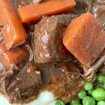 close up of guinness beef stew with carrots and peas