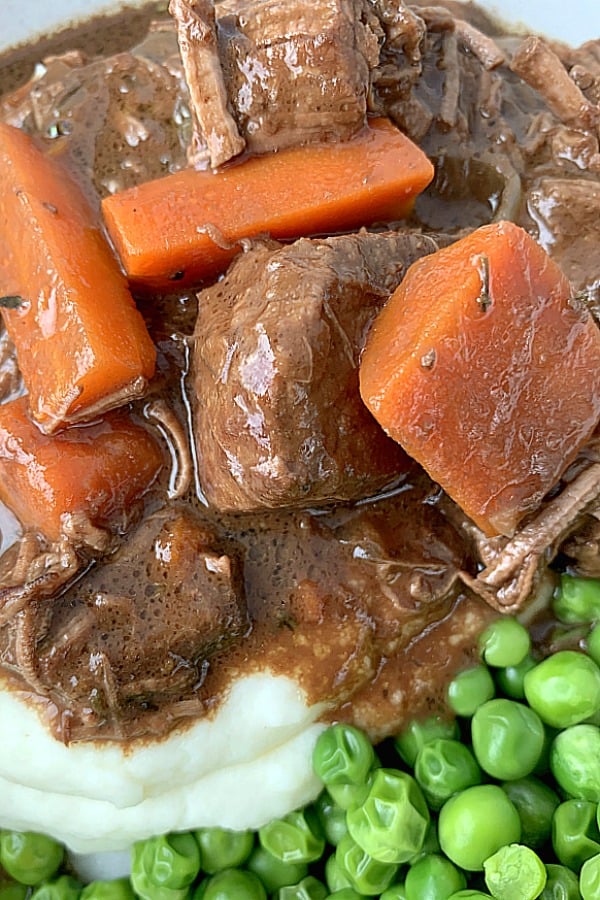 close up of guinness beef stew with carrots and peas