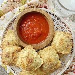 air fryer toasted ravioli on plate with bowl of pizza sauce for dipping