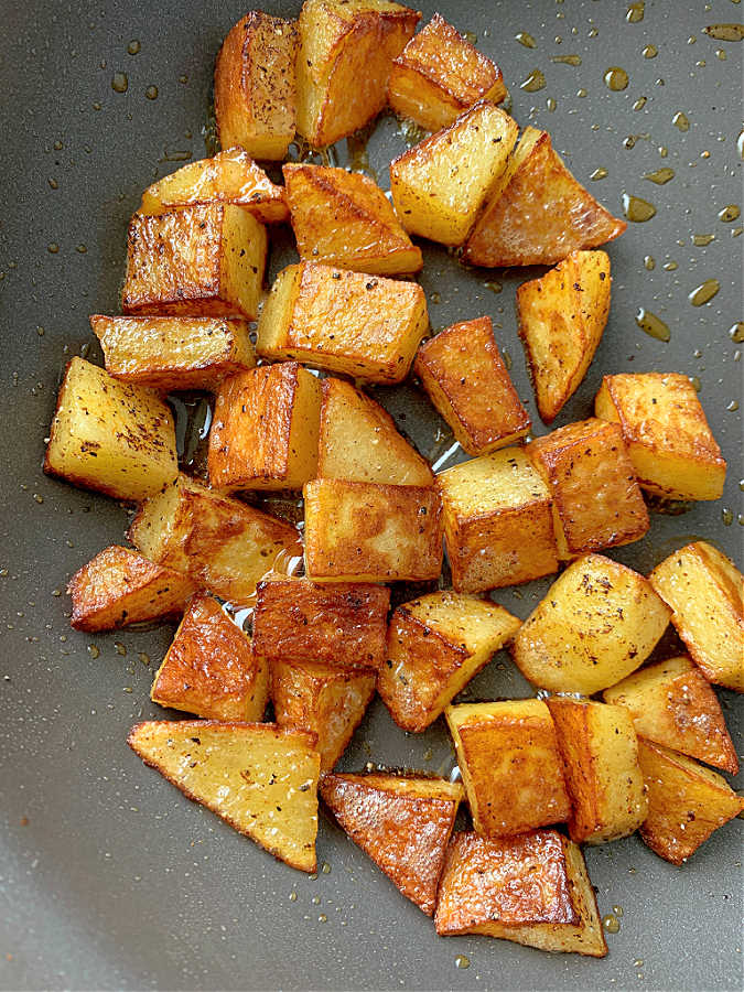 showing freshly fried breakfast potatoes in a skillet