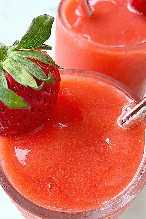 close up of two glasses of frozen strawberry daiquiris