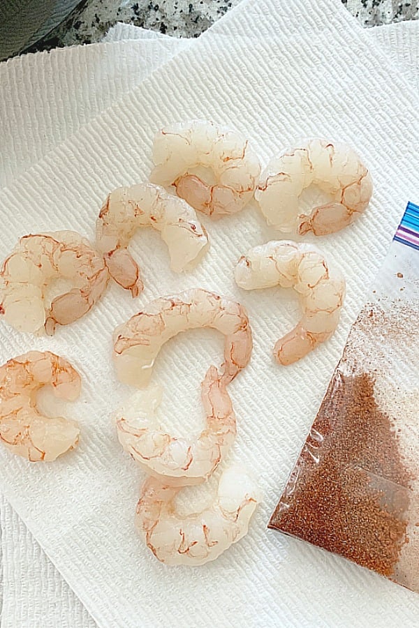 shrimp on a paper towel next to spice rub