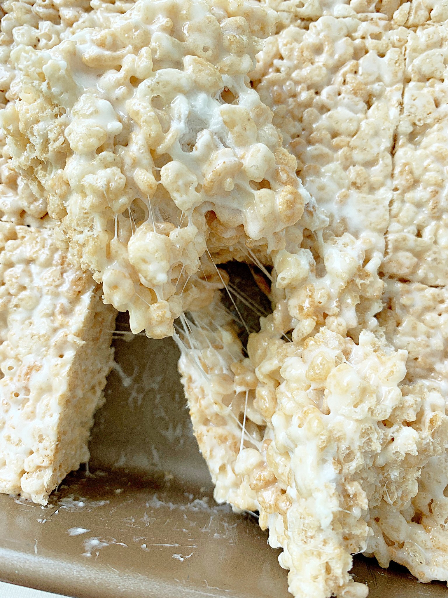 gooey cut warm krispie treats in the pan