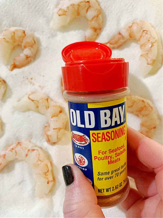 thawed shrimp drying on paper towel and being seasoned with Old Bay