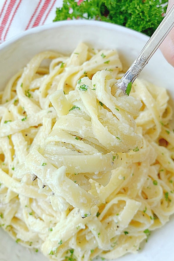 fork full of alfredo pasta