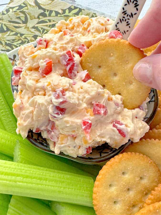 dipping a Ritz cracker into a bowl of homemade pimento cheese