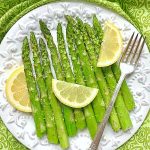 air fryer asparagus on plate with lemons