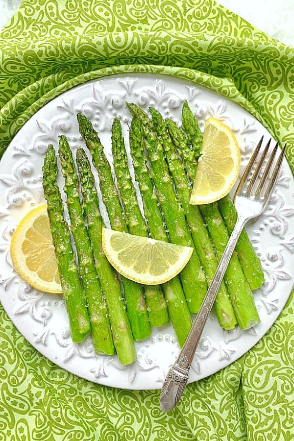 air fryer asparagus on plate with lemons