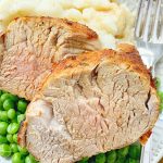 pork tenderloin sliced on a plate with potatoes and peas