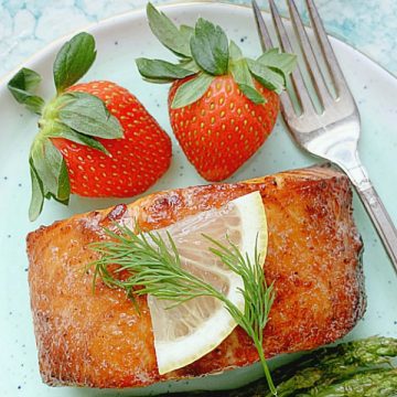 air fryer salmon on plate with asparagus and strawberries