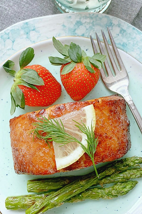 air fryer salmon on plate with asparagus and strawberries