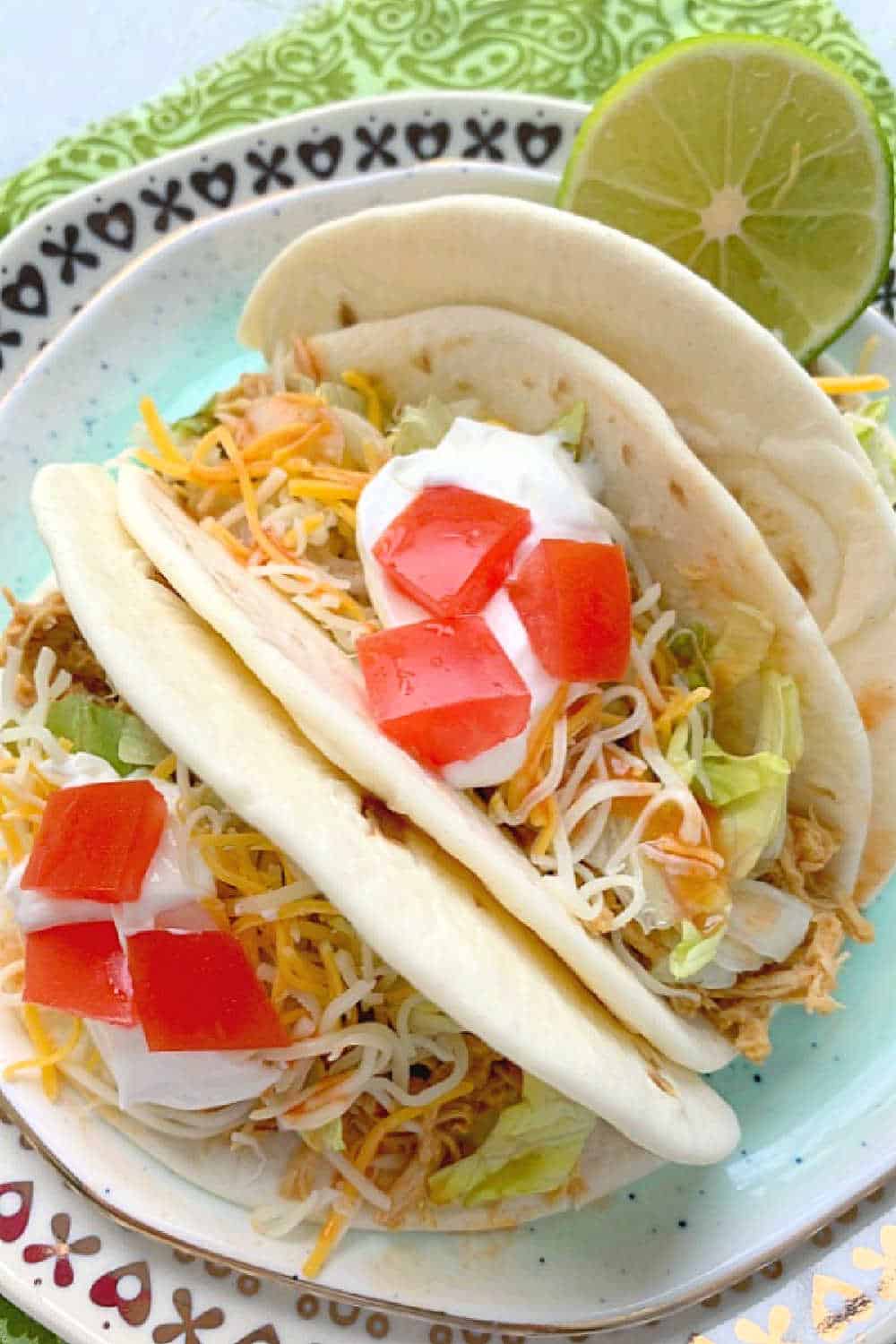 Crockpot Chicken Tacos are always a family-favorite meal. A few surprising ingredients make this shredded chicken taco filling irresistible. via @foodtasticmom