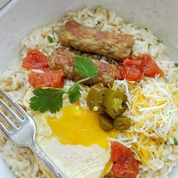 breakfast rice bowl overhead view with orange juice and a fork