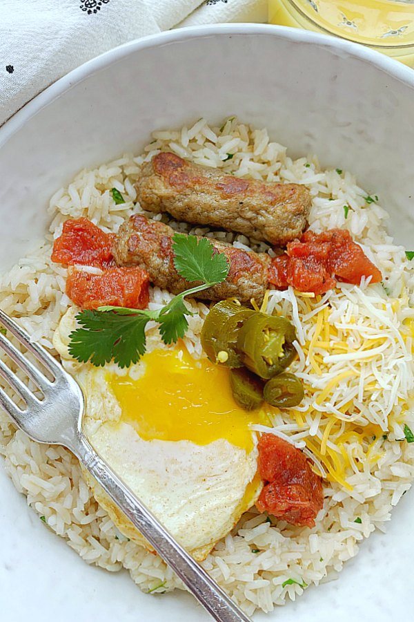 breakfast rice bowl overhead view with orange juice and a fork