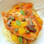 chicken cacciatore in a dish over pasta