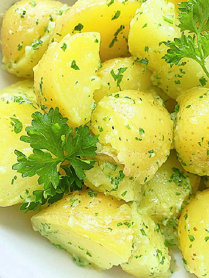 a close up of fresh buttered parsley potatoes