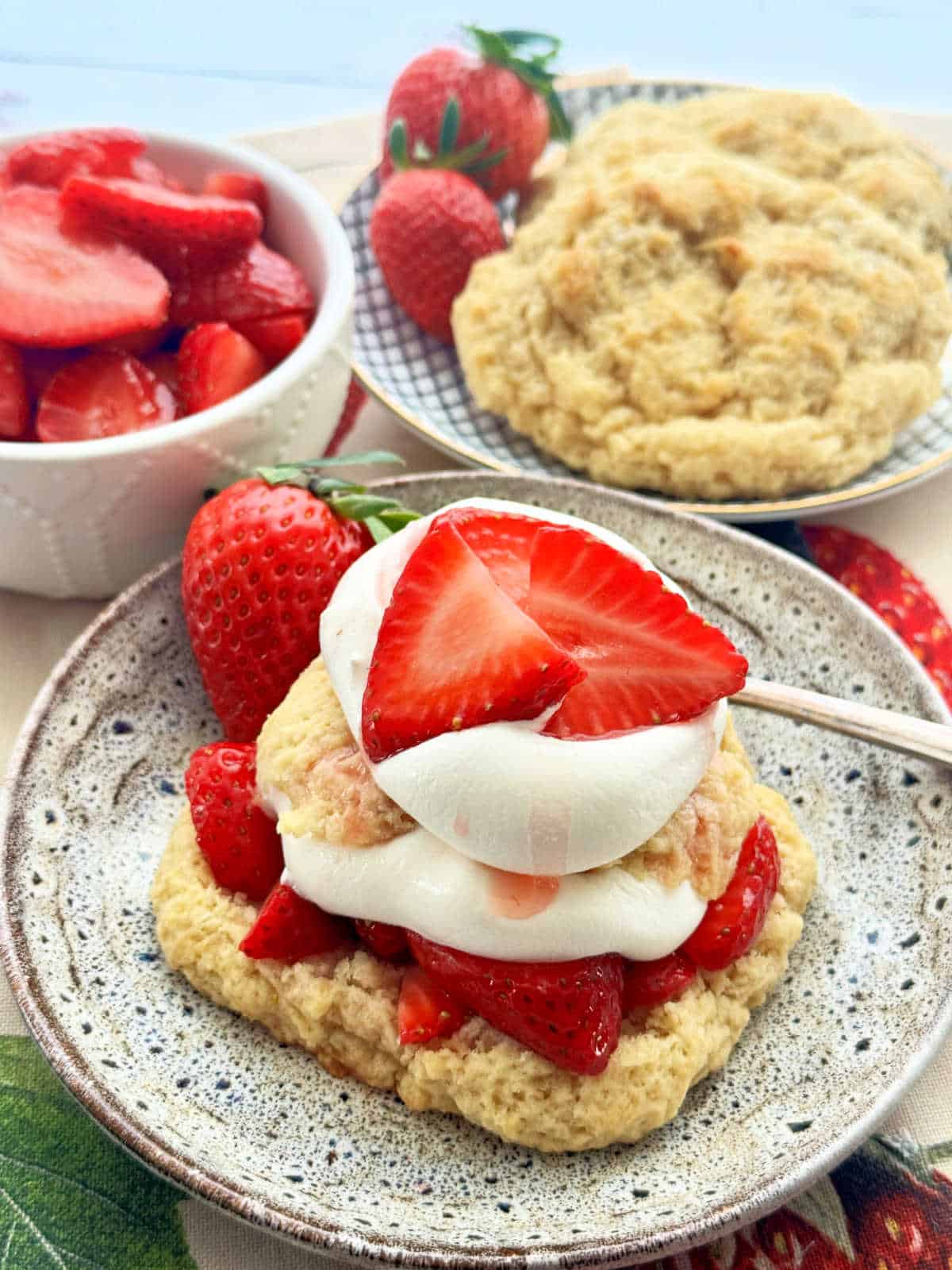 showing off a plate of strawberry shortcake layered with fresh strawberries and whipped cream