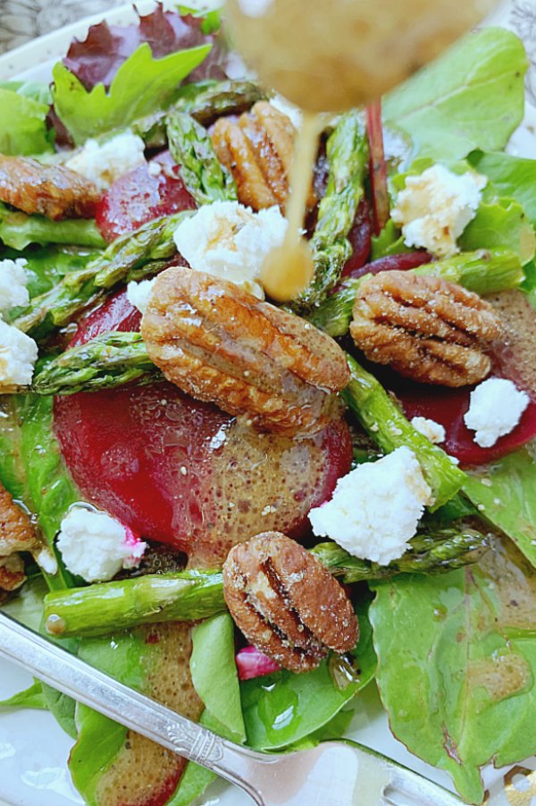 pouring french vinaigrette onto the salad
