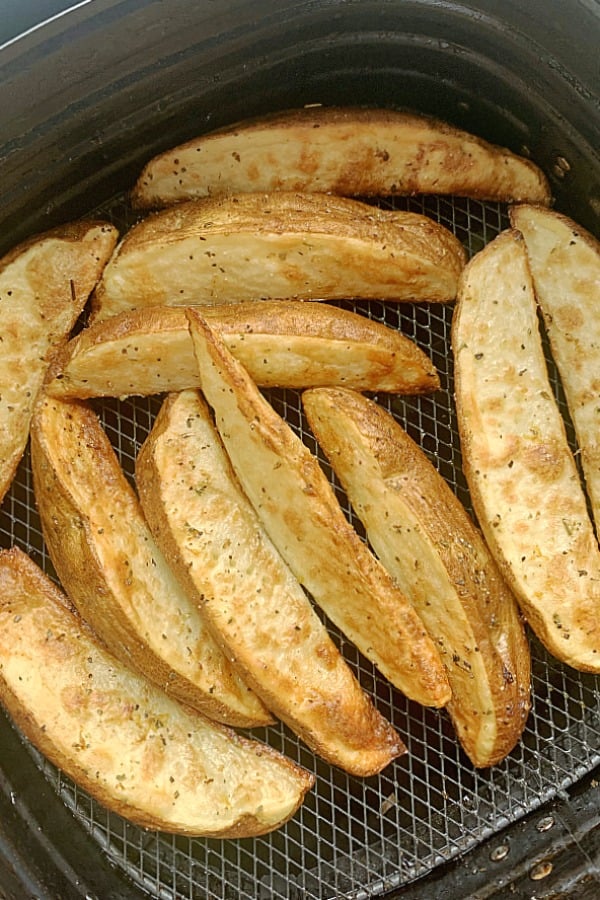 potato wedges in an air fryer basket