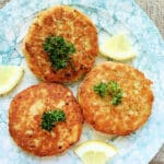 three plated salmon patties garnished with fresh parsley