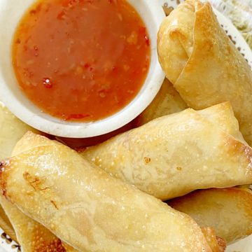 air fryer egg rolls on a plate with dipping sauce